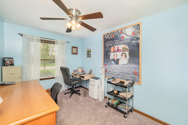 office space featuring light colored carpet, ceiling fan, and baseboards