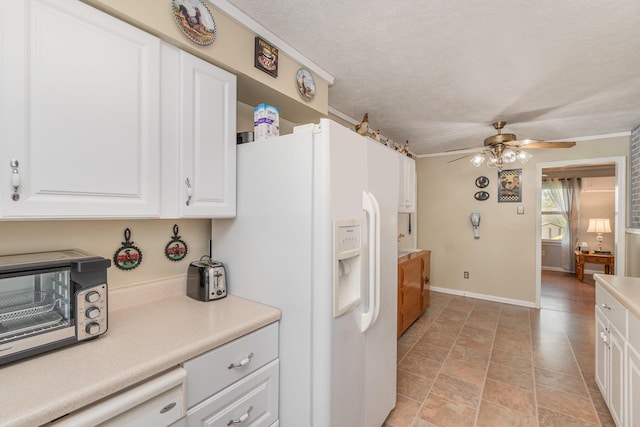 kitchen with a ceiling fan, white appliances, light countertops, white cabinets, and stone finish floor