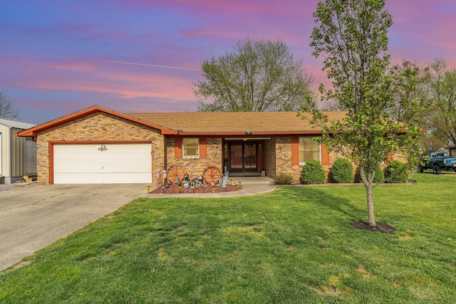 ranch-style house with a garage, brick siding, a front lawn, and concrete driveway