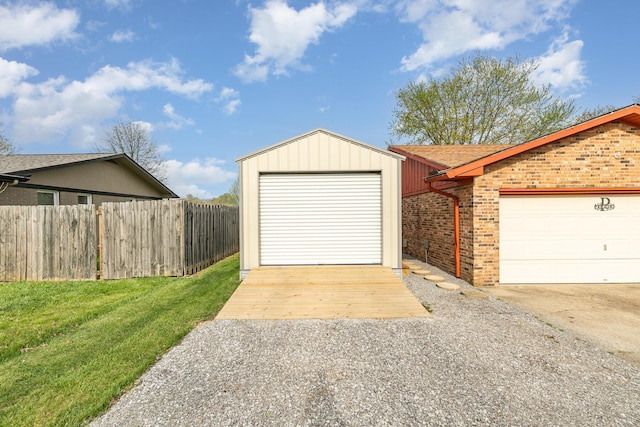 garage with fence and concrete driveway