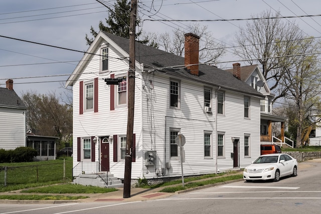 view of front facade featuring fence and a chimney