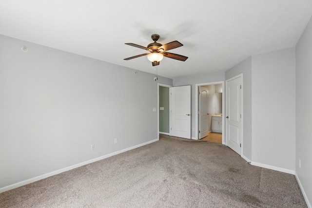 unfurnished bedroom featuring baseboards, ceiling fan, carpet, and ensuite bath