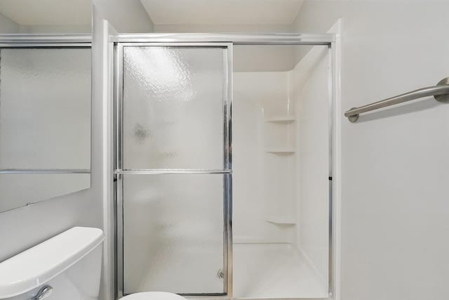 bathroom featuring a shower stall and toilet