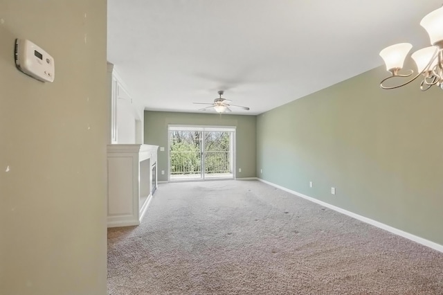 unfurnished living room with a fireplace, baseboards, light carpet, and ceiling fan with notable chandelier