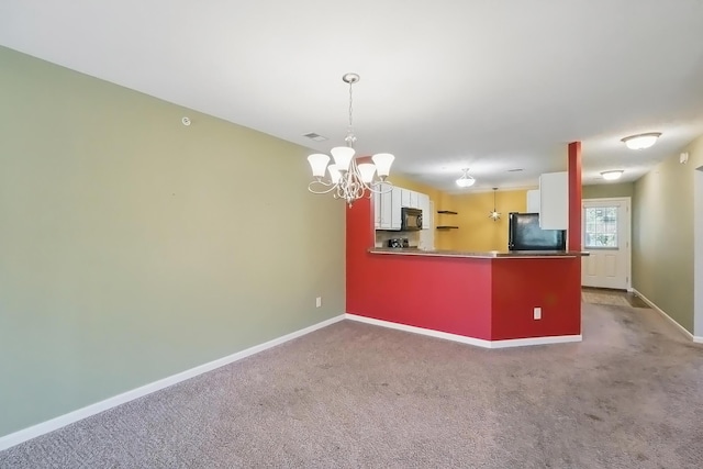 kitchen featuring black microwave, baseboards, refrigerator, and a notable chandelier