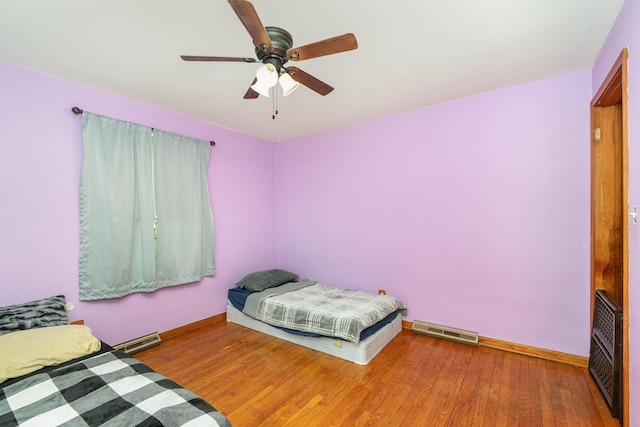 bedroom with visible vents, baseboards, and wood finished floors