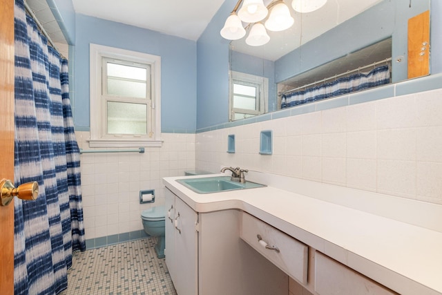 bathroom featuring a healthy amount of sunlight, a notable chandelier, toilet, and tile walls