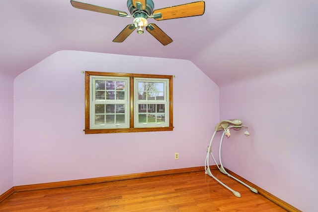 additional living space with baseboards, a ceiling fan, vaulted ceiling, and light wood-style flooring