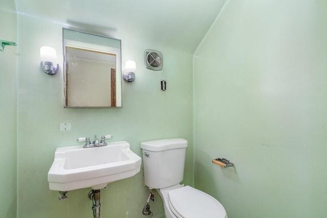 bathroom with toilet, visible vents, and a sink