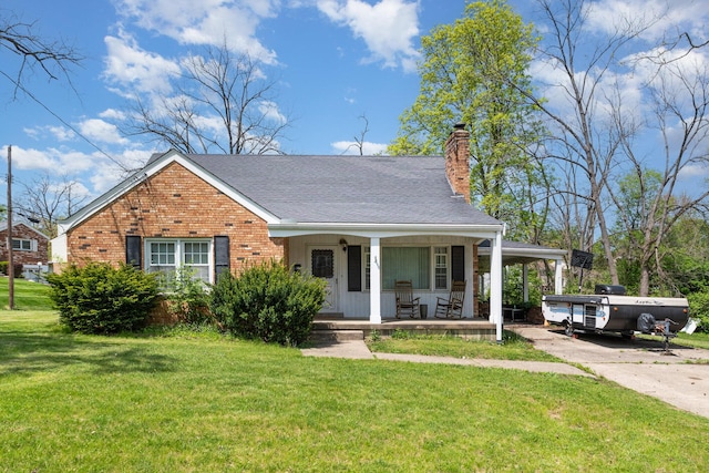 view of front of house featuring covered porch, a chimney, a front lawn, and brick siding