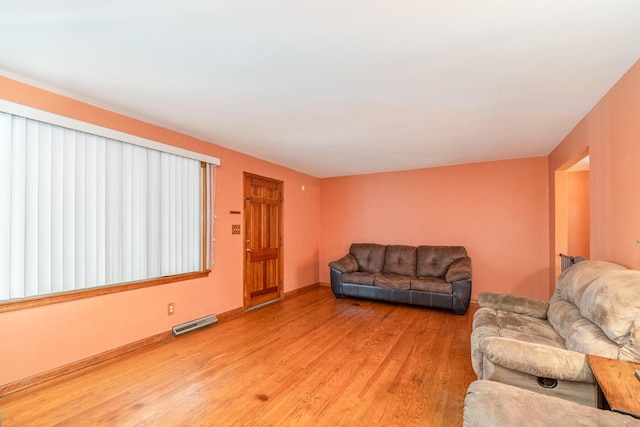 living area featuring baseboards, light wood-style flooring, and visible vents