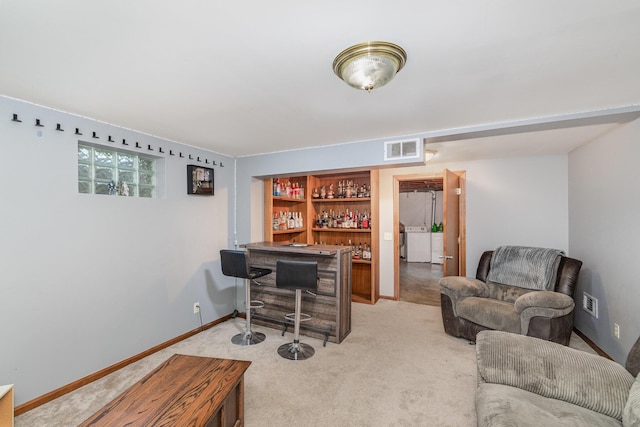living area featuring a bar, separate washer and dryer, carpet, and visible vents