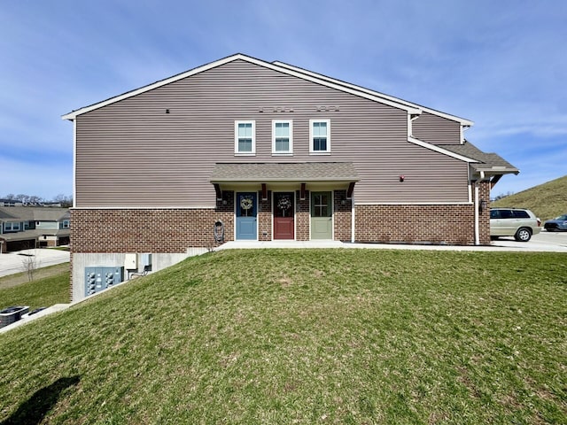 traditional home featuring a front lawn and brick siding