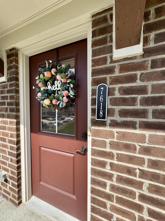 view of exterior entry featuring brick siding