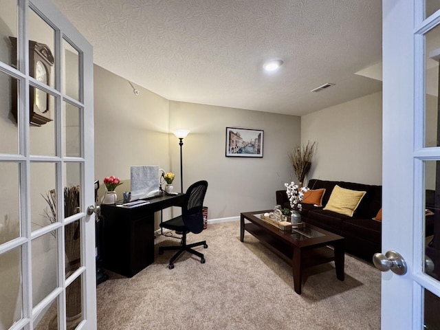 office space with visible vents, french doors, carpet flooring, and a textured ceiling
