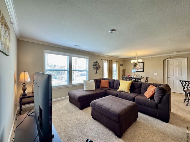 carpeted living room featuring a textured ceiling, visible vents, ornamental molding, and an inviting chandelier