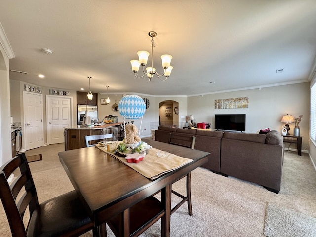 dining area featuring arched walkways, a chandelier, carpet, and crown molding