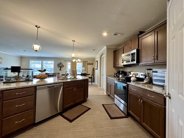 kitchen featuring crown molding, stainless steel appliances, visible vents, and a sink