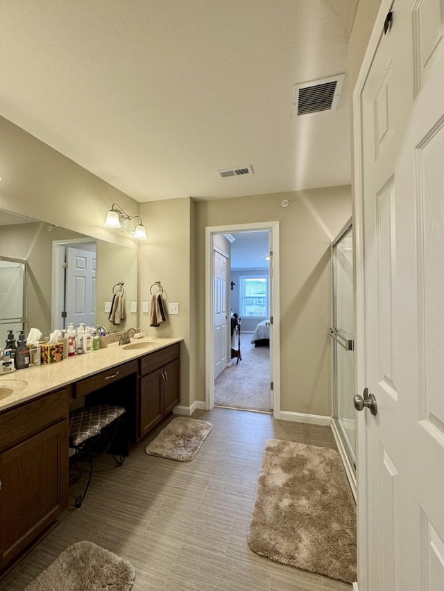 bathroom featuring a sink, double vanity, visible vents, and a stall shower