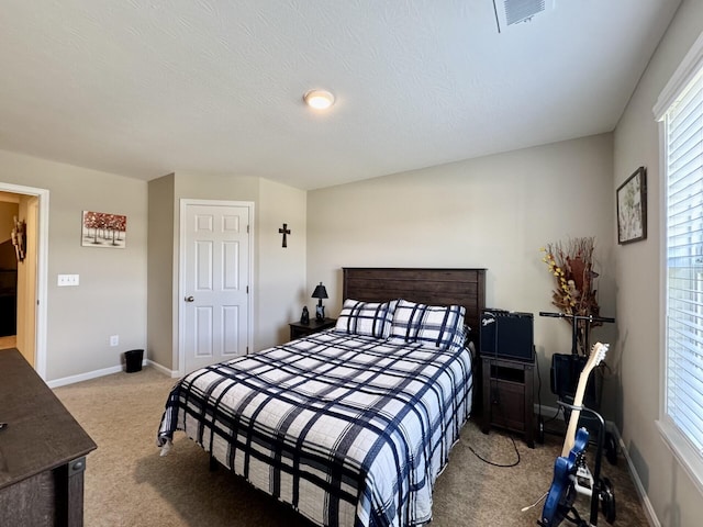 carpeted bedroom featuring baseboards and visible vents
