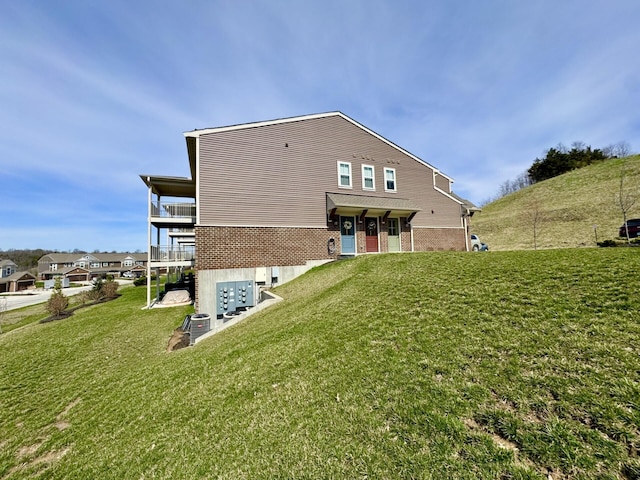rear view of property with brick siding and a yard