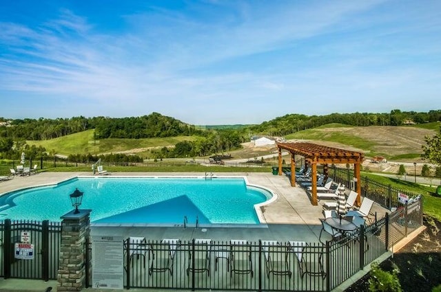 community pool featuring fence, a pergola, and a patio area