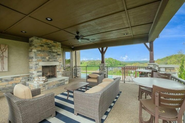 view of patio / terrace with an outdoor living space with a fireplace and ceiling fan