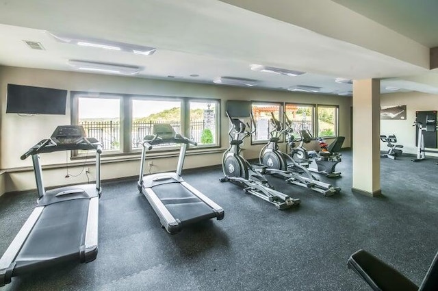 exercise room featuring a wealth of natural light, visible vents, and baseboards