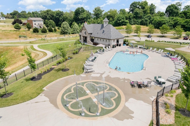 community pool featuring fence, a yard, and a water play area