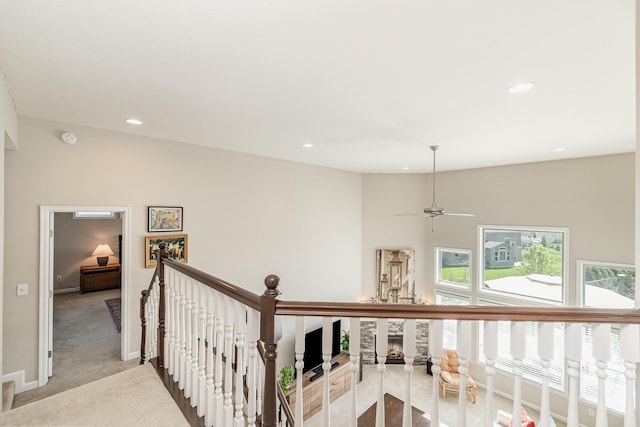 hall featuring baseboards, recessed lighting, light carpet, and an upstairs landing