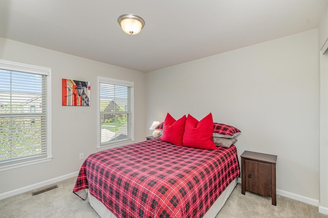 bedroom with carpet, visible vents, and baseboards