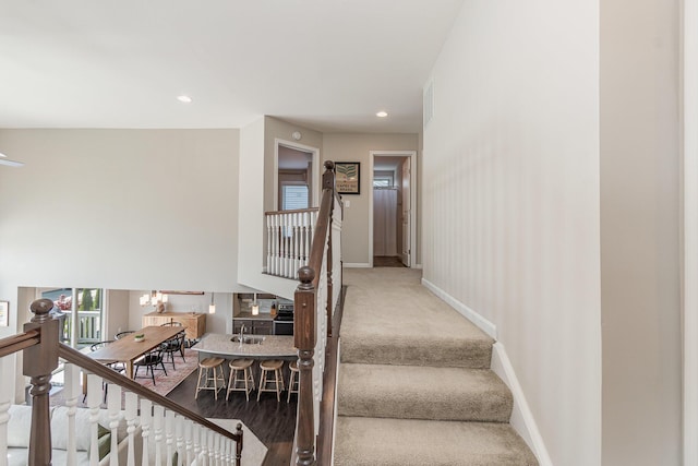 stairs with carpet flooring, visible vents, baseboards, recessed lighting, and a notable chandelier