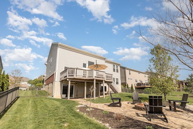 back of house with an outdoor fire pit, a yard, a wooden deck, and a fenced backyard