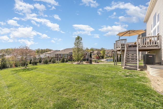 view of yard with a residential view, a deck, stairs, and central AC