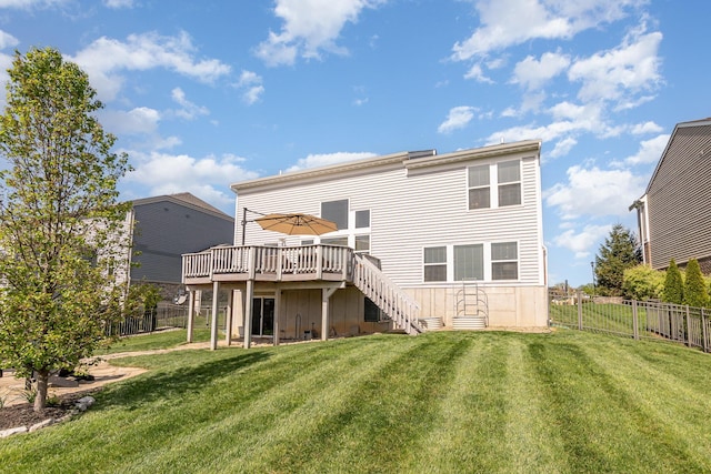 back of property with a deck, fence, a yard, and stairs