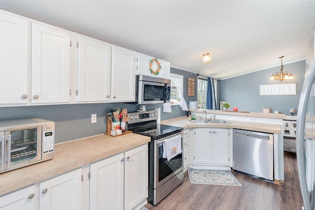 kitchen with light countertops, wood finished floors, appliances with stainless steel finishes, and a sink