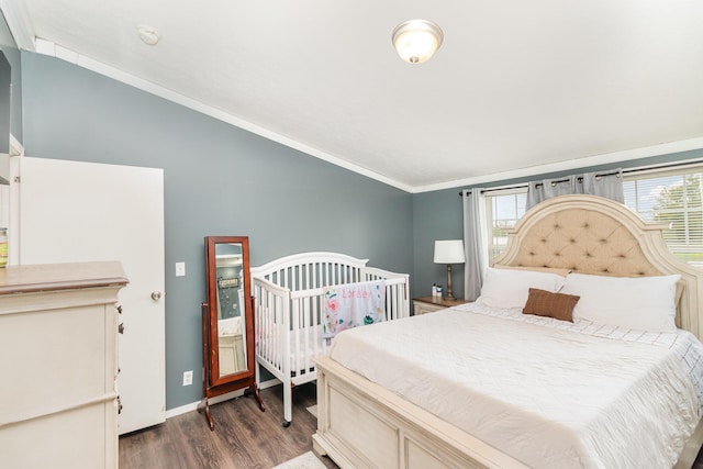 bedroom featuring lofted ceiling, ornamental molding, baseboards, and wood finished floors