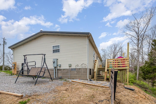 view of property exterior with a wooden deck and stairs