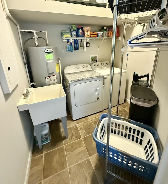 laundry area with tile patterned floors, washer and clothes dryer, baseboards, water heater, and laundry area