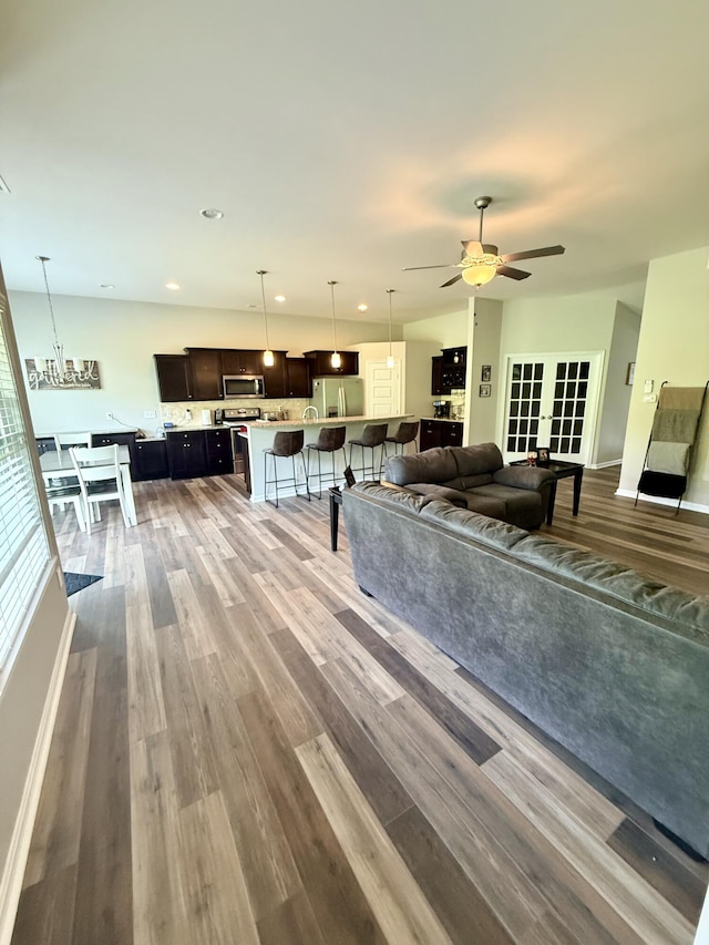 living room with recessed lighting, wood finished floors, a ceiling fan, and french doors
