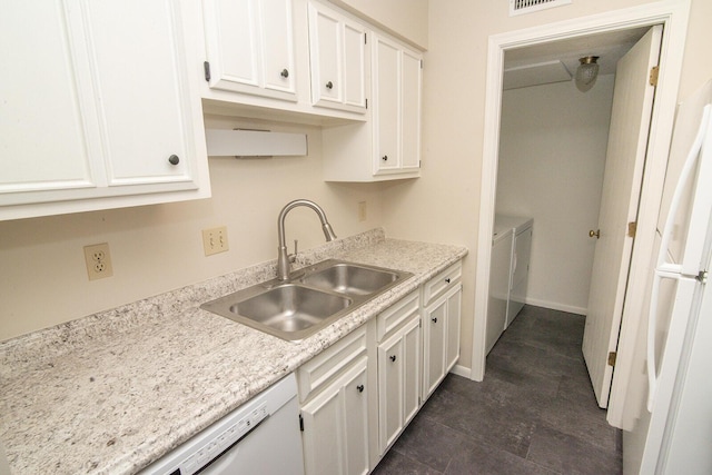 kitchen featuring washer and dryer, a sink, light countertops, white cabinetry, and visible vents