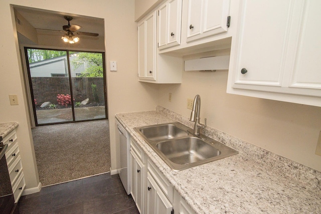 kitchen featuring a sink, light countertops, white cabinets, and dark carpet