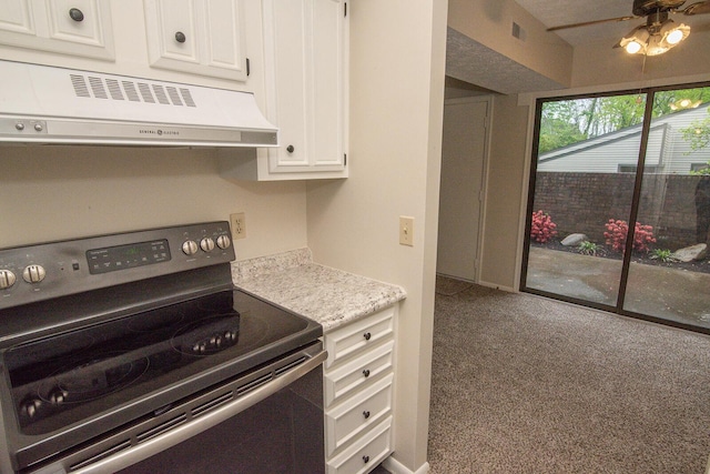 kitchen featuring visible vents, stainless steel range with electric stovetop, light countertops, white cabinets, and extractor fan