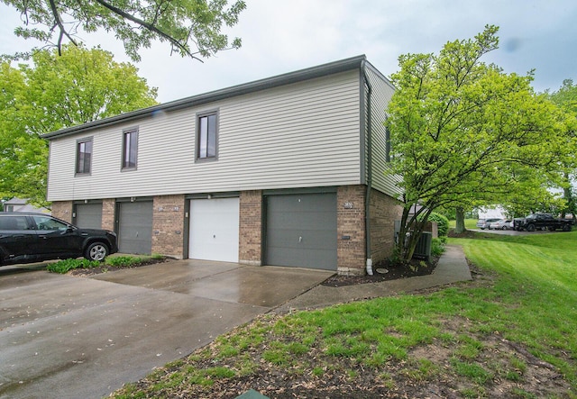 view of front facade with brick siding, a front lawn, an attached garage, and concrete driveway