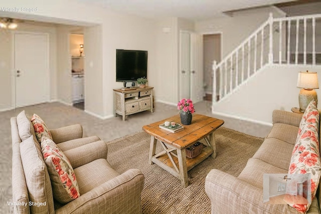 living area with stairway, baseboards, and carpet flooring