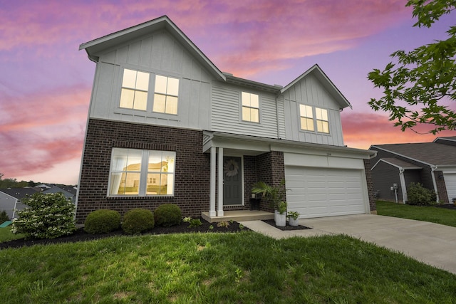 traditional-style house with board and batten siding, driveway, a garage, brick siding, and a yard