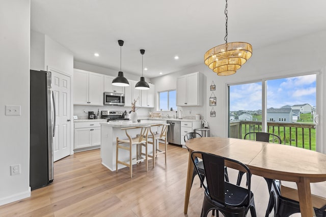 dining space featuring light wood-type flooring, recessed lighting, and a chandelier