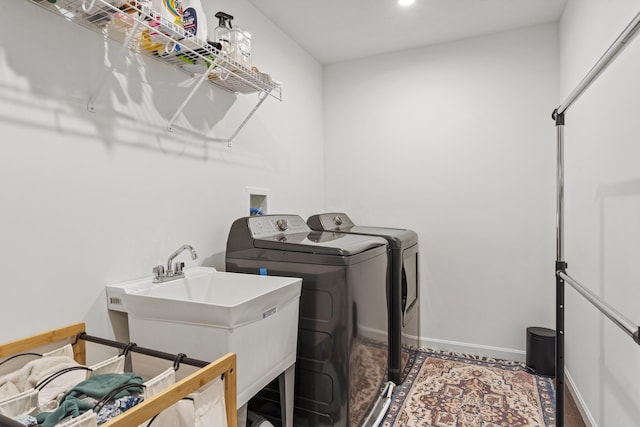 laundry room featuring washer and dryer, laundry area, baseboards, and a sink