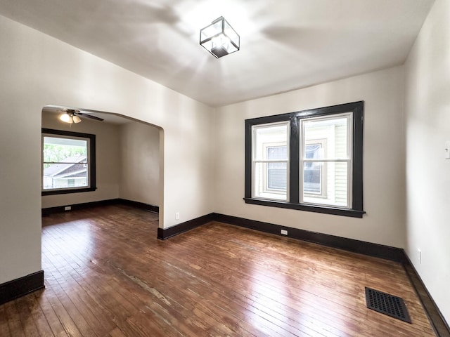 38 W 28th St, Covington, KY 41015 - unfurnished room featuring arched walkways, dark wood finished floors, visible vents, and baseboards