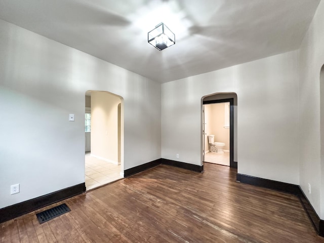 38 W 28th St, Covington, KY 41015 - empty room featuring wood-type flooring, arched walkways, visible vents, and baseboards